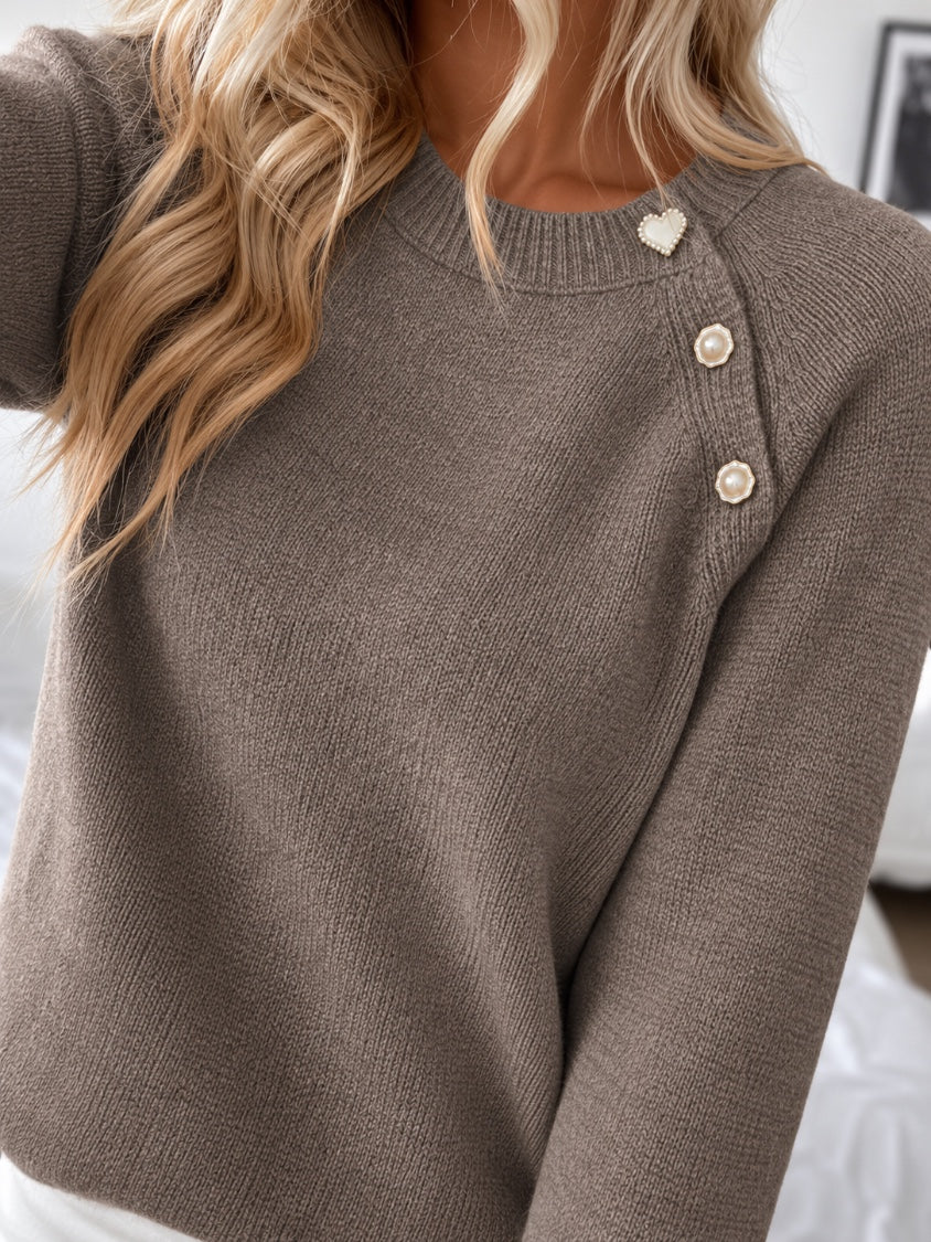 Close-up of the pearl buttons and heart button on the knit sweater